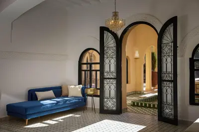 a living room with a blue couch and two arches at Dar Banati Palmeraie in Marrakech