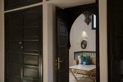 a hallway with two black doors and a table at Dar Banati Palmeraie in Marrakech