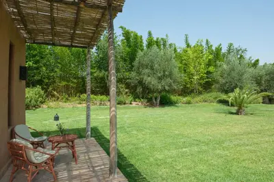 a porch with a swing and a table and chairs at Villa Jennabelle in Marrakech