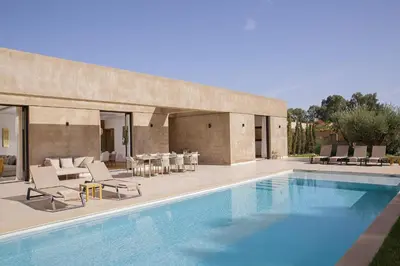 a swimming pool with lounge chairs and a house at Villa PEPE in Marrakech