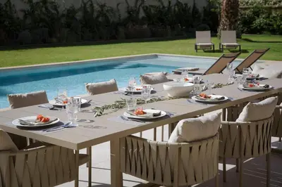a table set for a meal next to a pool at Villa PEPE in Marrakech