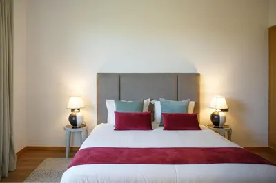 a bedroom with a large bed with red and blue pillows at ADA ADA modern villa with heated private pool next city center in Marrakech