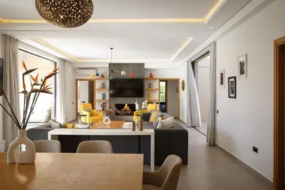 a kitchen and living room with a table and a couch at ADA ADA modern villa with heated private pool next city center in Marrakech