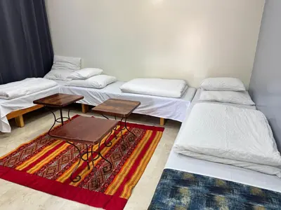a room with three beds and a rug at B1 In Center of Marrakech, Geliz-Majorelle, Bab-Dokala, No need for Taxi in Marrakech