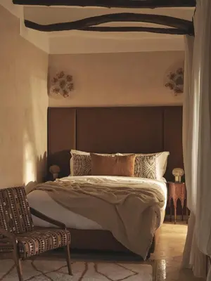 a bedroom with a large bed and a chair at IZZA Marrakech in Marrakech