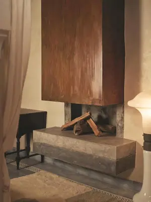 a fireplace with a wooden cabinet and wooden sticks at IZZA Marrakech in Marrakech