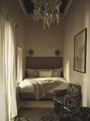 a bedroom with a bed and a chandelier at IZZA Marrakech in Marrakech