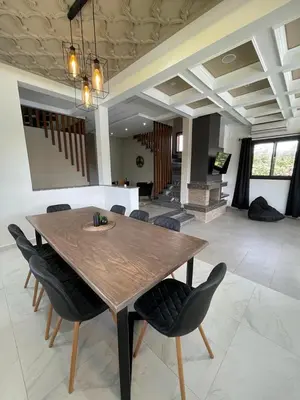 a dining room with a wooden table and chairs at Villa Amèle,calme,Ensoleillé,Piscine,Salle de jeux in Marrakech