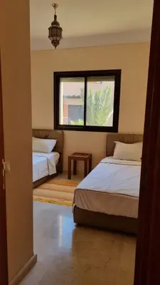a bedroom with two beds and a window at Appartement paisible et abordable Palmeraie Marrakech in Dar Caïd Layadi