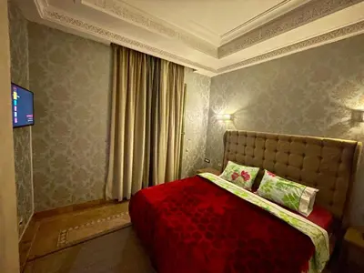 a bedroom with a bed with a red comforter at Au Temps Des Fleurs - Marrakech in Marrakech