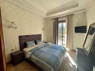 a bedroom with a bed and a large window at Au Temps Des Fleurs - Marrakech in Marrakech