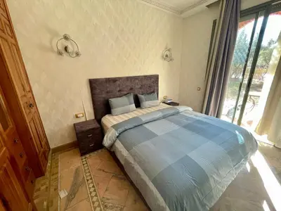 a bedroom with a large bed with a large window at Au Temps Des Fleurs - Marrakech in Marrakech