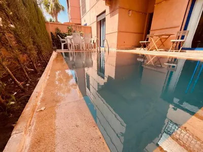 a swimming pool next to a building at Villa Talmoulkt Familiale in Marrakech