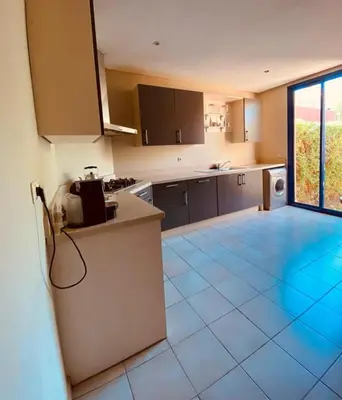 a kitchen with a tile floor and a large window at Villa Talmoulkt Familiale in Marrakech
