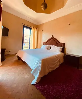 a bedroom with a large bed in a room at Villa Talmoulkt Familiale in Marrakech