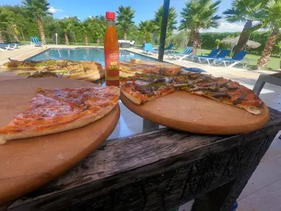 two slices of pizza sitting on wooden pizzas on a table at Luxury heated pool Villa Marrakech in Marrakech