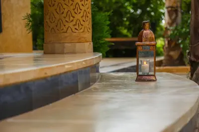 a bottle sitting on a table with a candle in it at Luxury heated pool Villa Marrakech in Marrakech