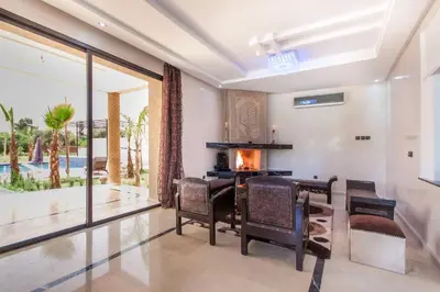 a dining room with a table and chairs and a fireplace at Luxury heated pool Villa Marrakech in Marrakech