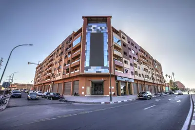 a large building with cars parked in front of it at Nour 5 el bellar in Marrakech