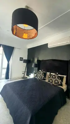 a bedroom with a large bed with a black comforter at Riad VIP Bed & Breakfast in Marrakech
