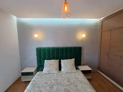 a bed with a green headboard in a bedroom at appartement en résidence in Marrakech
