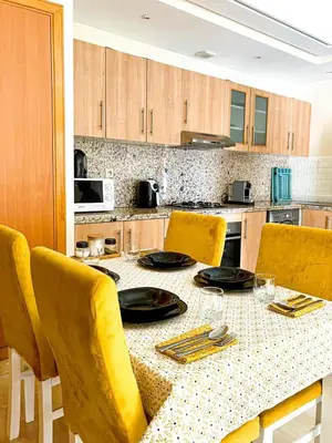 a kitchen with a table with yellow chairs and a table sidx sidx at appartement génial in Marrakech