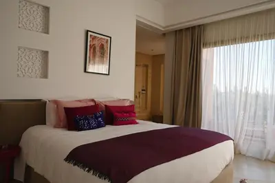 a bed in a hotel room with a large window at Maison Kenoosha Boutique Hotel & Spa in Marrakech