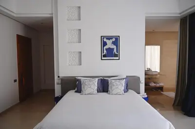 a bedroom with a white bed with blue pillows at Maison Kenoosha Boutique Hotel & Spa in Marrakech