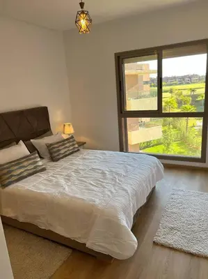 a bedroom with a large bed and a large window at Beautiful apartment in Golf City Marrakech in Marrakech