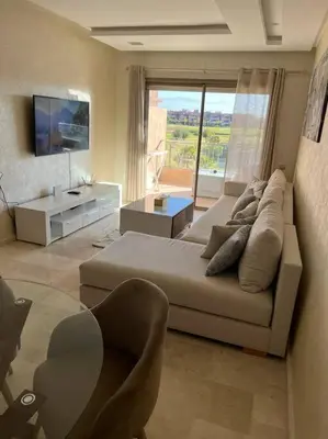 a living room with a couch and a tv at Beautiful apartment in Golf City Marrakech in Marrakech