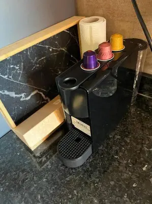 a coffee maker withcolored cups on top of a counter at Beautiful apartment in Golf City Marrakech in Marrakech