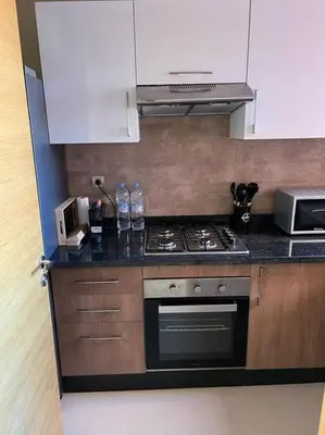 a kitchen with a stove and a microwave at Beautiful apartment in Golf City Marrakech in Marrakech
