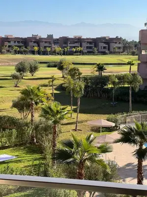 a view of a resort with palm trees and buildings at Beautiful apartment in Golf City Marrakech in Marrakech