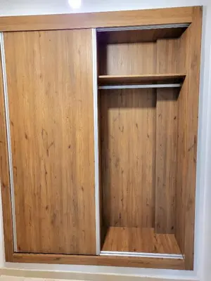 a wooden closet with wooden doors on a wall at Appartement centre-ville Marrakech Guéliz in Marrakech
