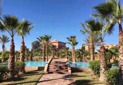 a resort with palm trees and a swimming pool at Appartement Hivernage M Avenue in Marrakech