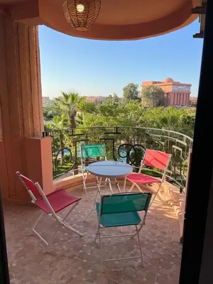a patio with a table and chairs on a balcony at Appartement Hivernage M Avenue in Marrakech