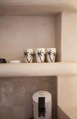 three cups sitting on a shelf next to a toaster at Cosy Riad in Marrakech