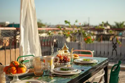 a table with plates of fruit on a balcony at Cosy Riad in Marrakech