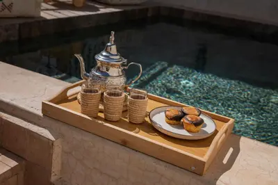 a tray with a tea kettle and a plate of pastries at Riad Kasbah El Mamoune in Marrakech