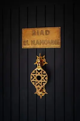 a gold sign that reads had hallowum on a wall at Riad Kasbah El Mamoune in Marrakech