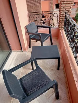 a pair of chairs and a table on a balcony at Lovely Marrakech in Marrakech