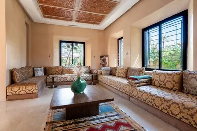 a living room with couches and a table at Villa les Palmiers in Marrakech