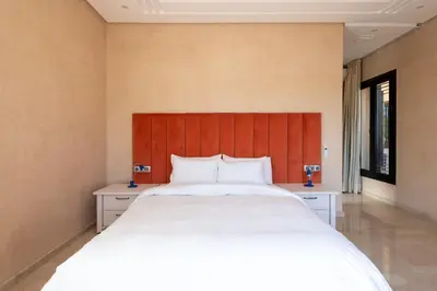 a bedroom with a large bed with a red headboard at Villa les Palmiers in Marrakech