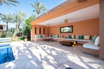 an outdoor patio with couches and a pool at Villa les Palmiers in Marrakech