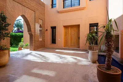 a courtyard with potted plants in front of a building at Villa les Palmiers in Marrakech