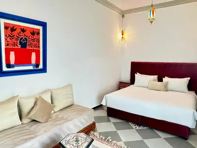 a bedroom with two beds and a couch at Riad Arrahma in Marrakech