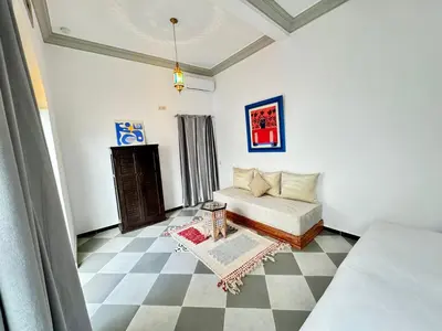 a living room with a bed and a checkered floor at Riad Arrahma in Marrakech