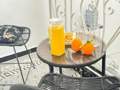 a table with two glasses of orange juice and snacks at Riad Arrahma in Marrakech