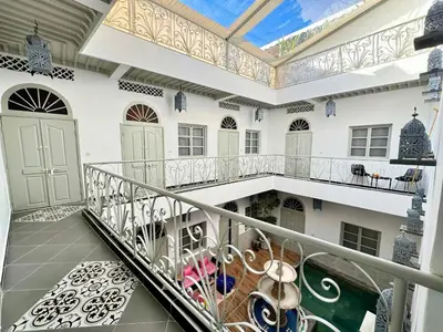 an indoor balcony of a house with white walls at Riad Arrahma in Marrakech
