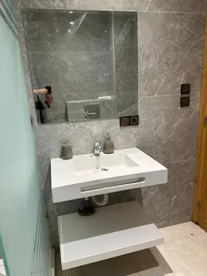 a bathroom with a white sink and a mirror at APPARTEMENT JAWHARA HIVERNAGE in Marrakech